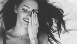 Amazing girl is lying in bed and smiling to you